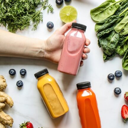 Vibrant smoothies surrounded by fresh fruits and vegetables, perfect for a healthy lifestyle.